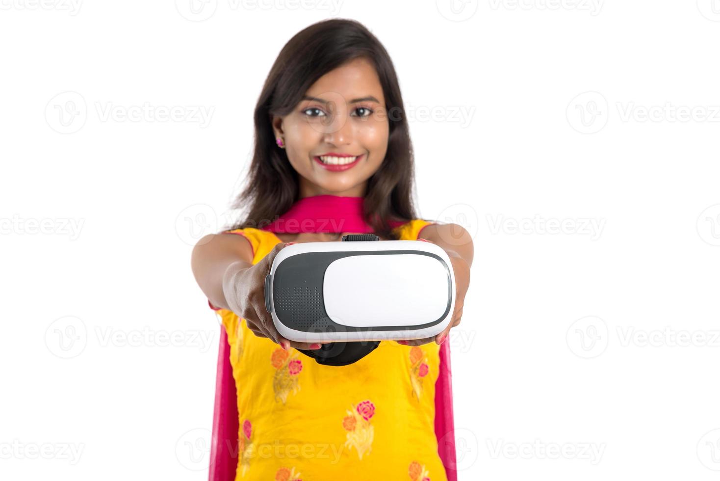 Indisches traditionelles junges Mädchen, das VR-Gerät, VR-Box, Brille, 3D-Virtual-Reality-Brille hält und zeigt, Mädchen mit moderner Bildgebungstechnologie auf weißem Hintergrund. foto