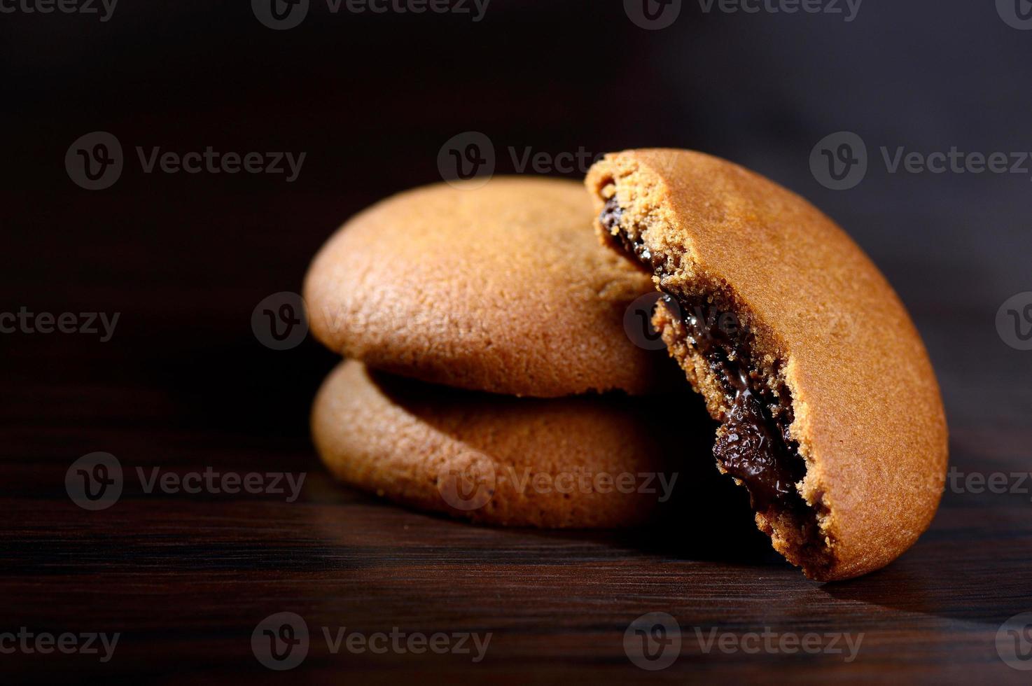 Kekse gefüllt mit Schokoladencreme. Schokoladencreme-Kekse. braune Schokoladenkekse mit Sahnefüllung auf schwarzem Hintergrund. foto