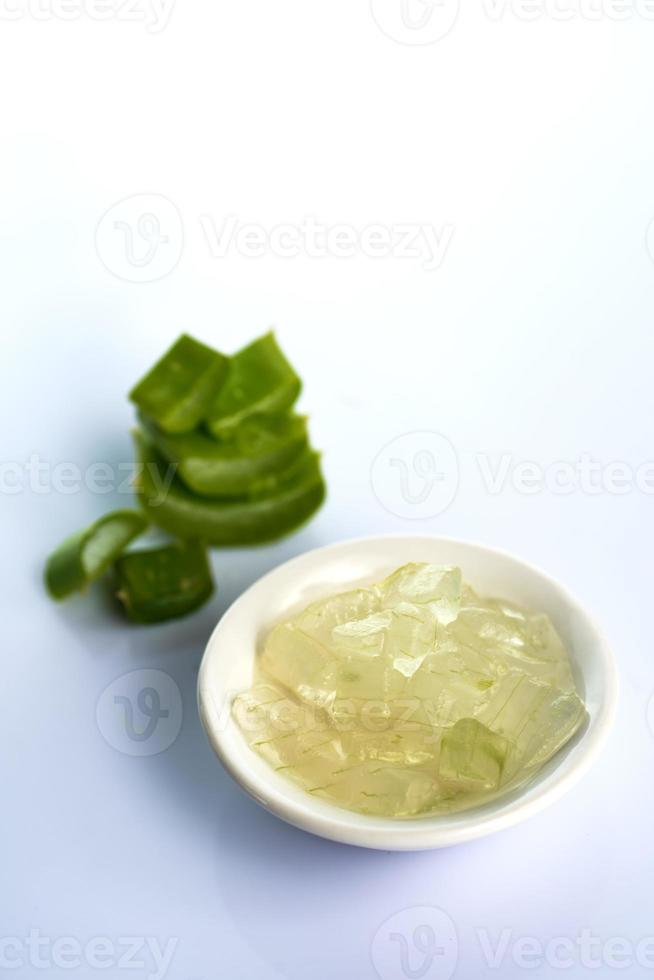 Scheiben von Aloe-Vera-Blättern und Aloe-Vera-Gel auf weißem Hintergrund. Aloe Vera ist ein sehr nützliches pflanzliches Arzneimittel zur Haut- und Haarpflege. foto