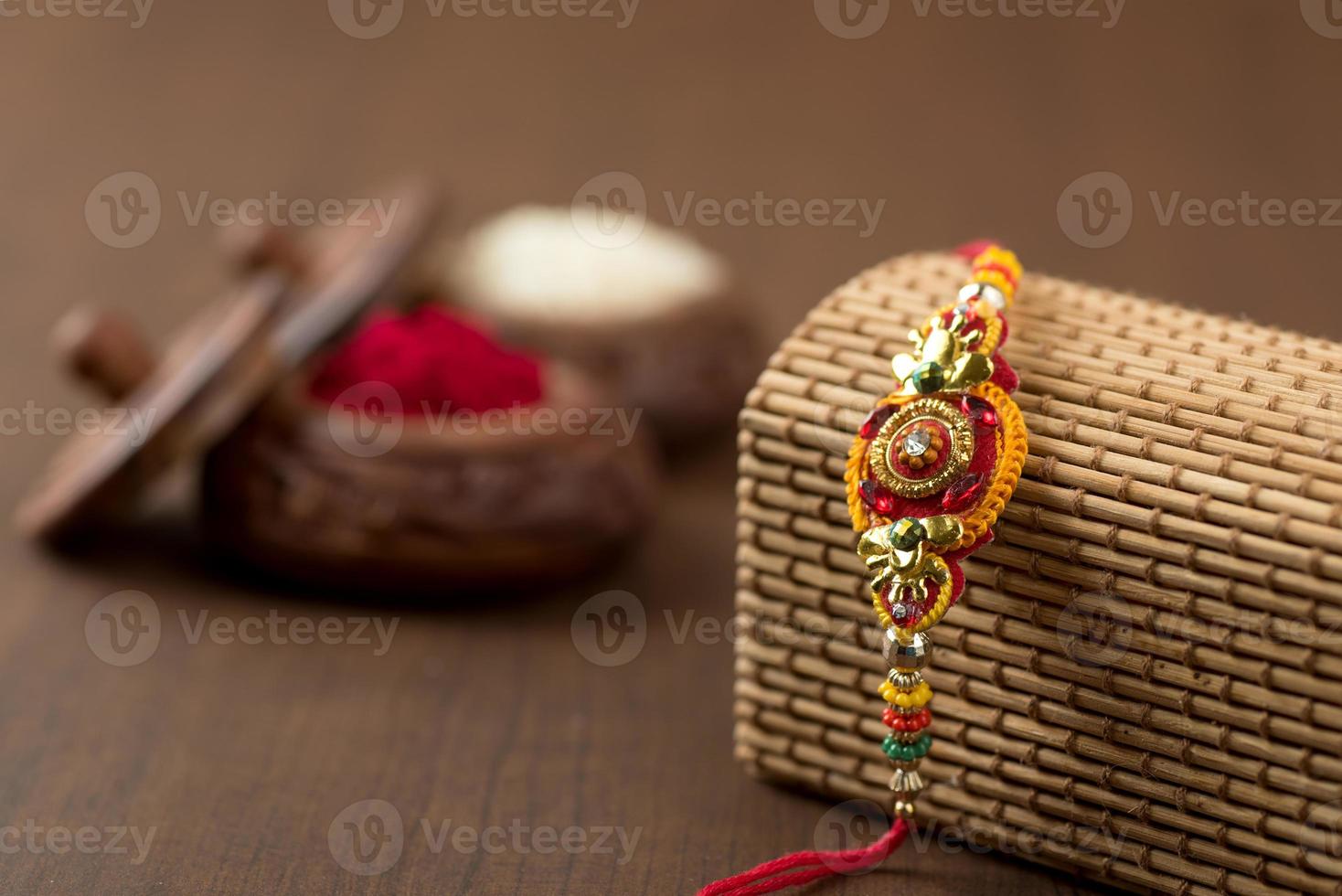 indischer Festival-Raksha-Bandhan-Hintergrund mit einem eleganten Rakhi, Reiskörnern und Kumkum. ein traditionelles indisches Armband, das ein Symbol der Liebe zwischen Brüdern und Schwestern ist. foto