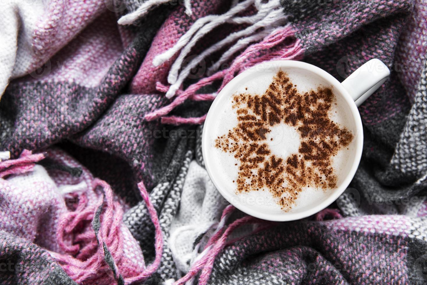 Kaffee mit Schneeflockenmuster auf einem warmen Wollplaid foto