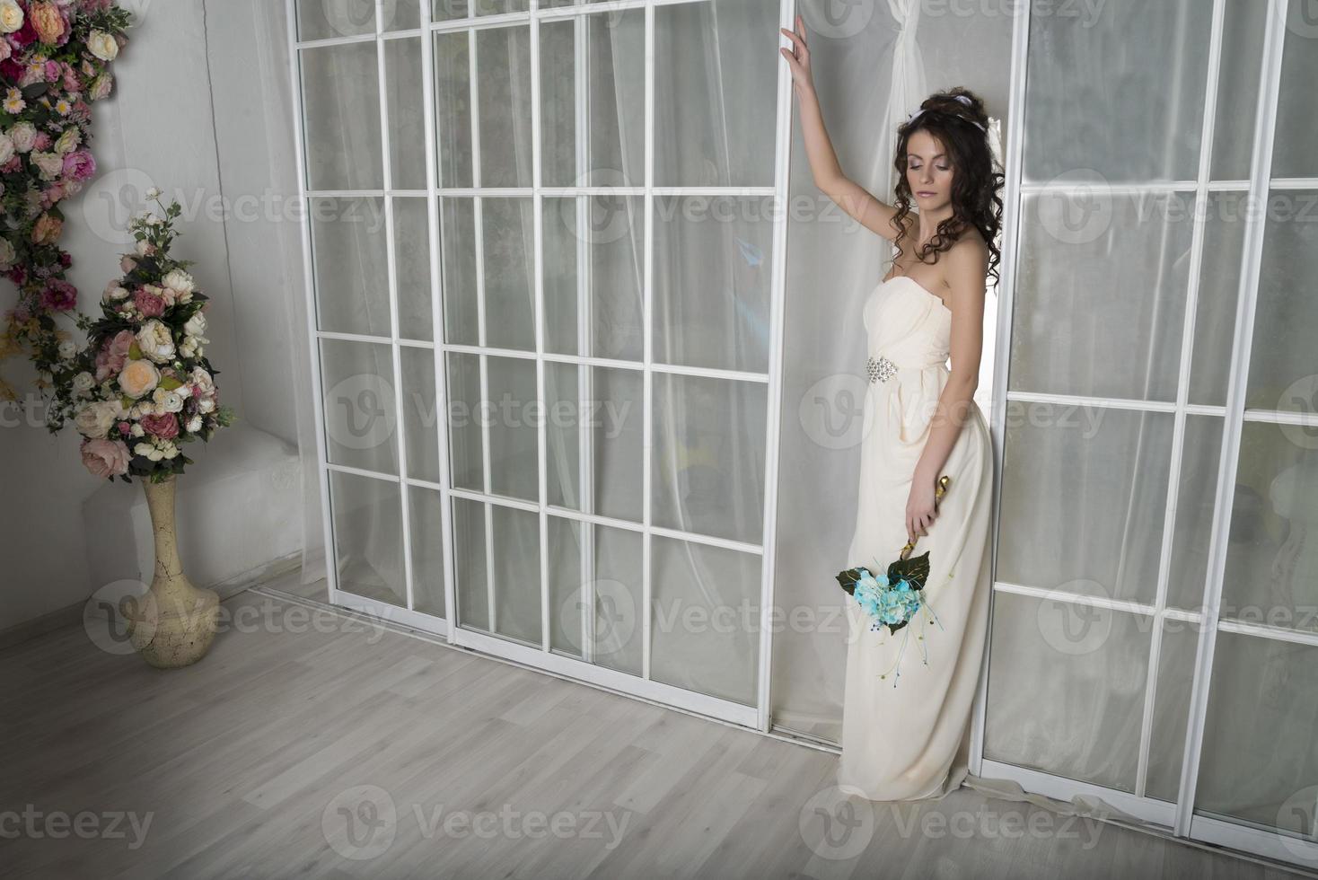 Mädchen in einem weißen Kleid an der Tür. foto