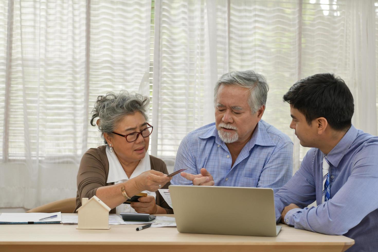 Älteres Ehepaar mit finanziellen Problemen muss Finanzpläne mit Finanzberater besprechen. foto