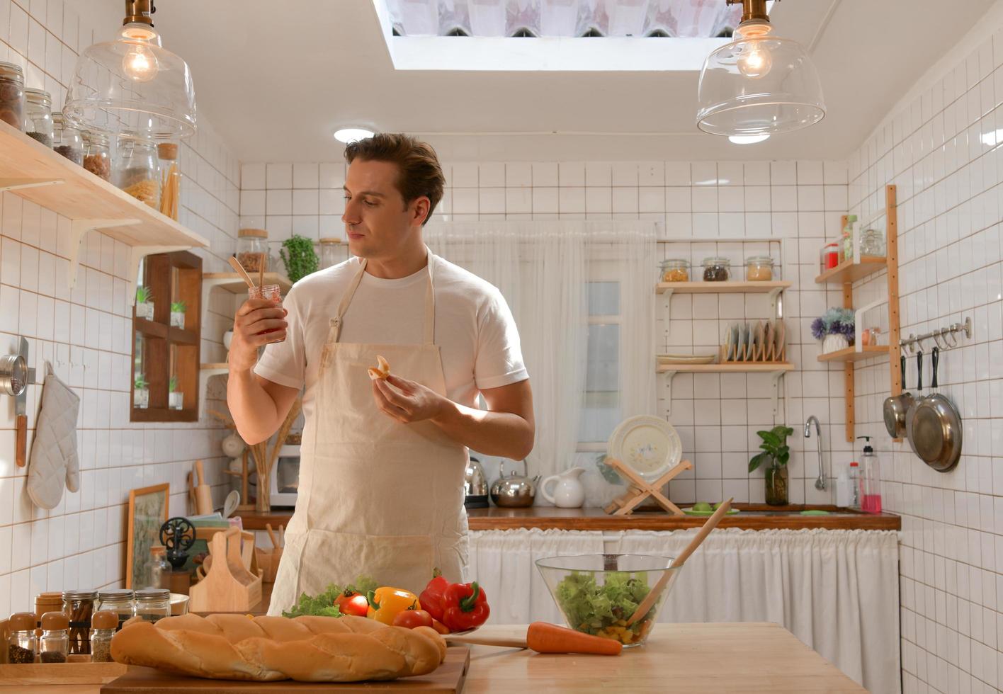 Der junge Mann entscheidet sich, ob er einen gesunden Salat oder Brot isst. foto