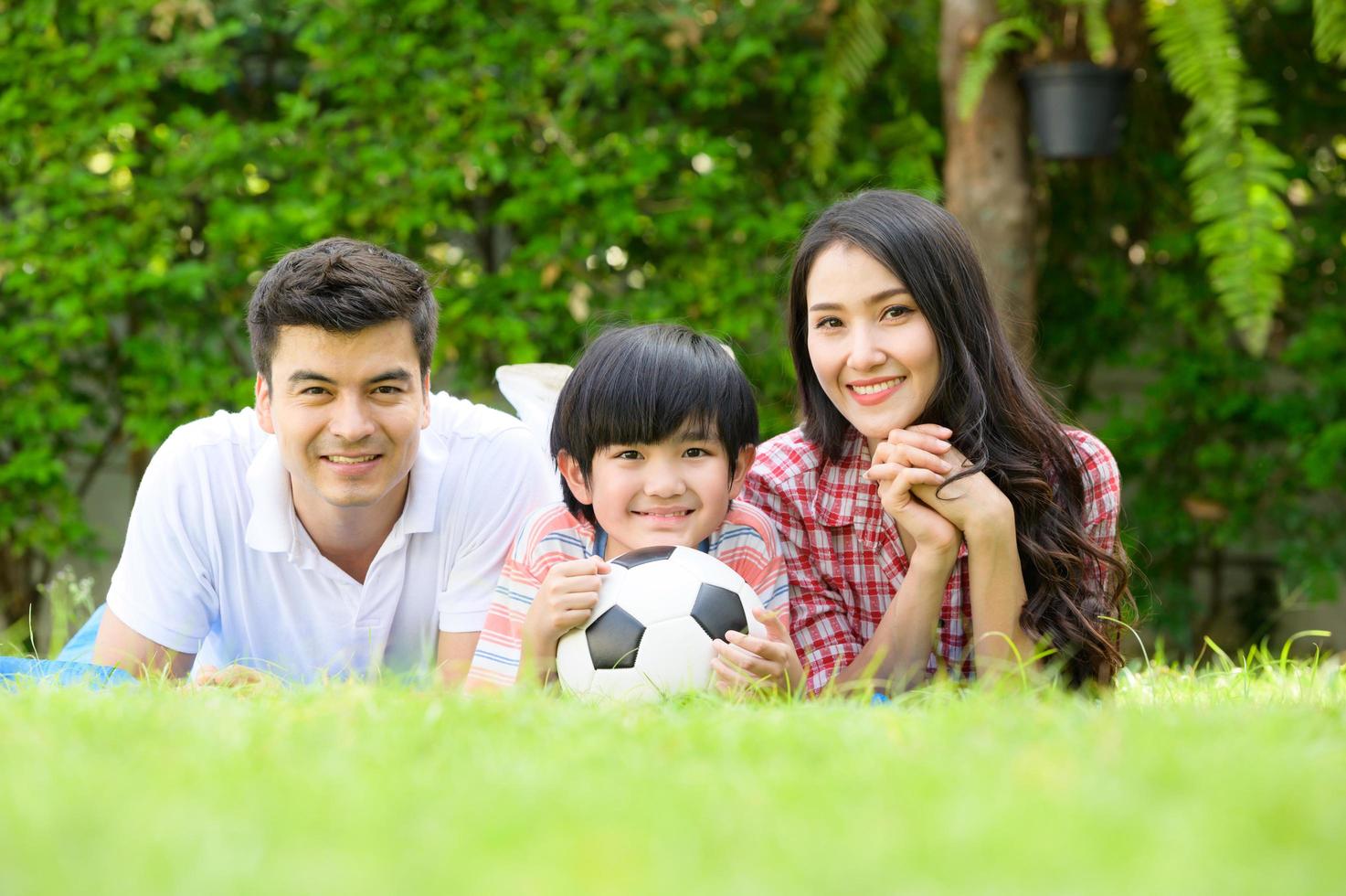 eine glückliche junge familie verbringt die ferien zusammen im garten vor dem haus. foto