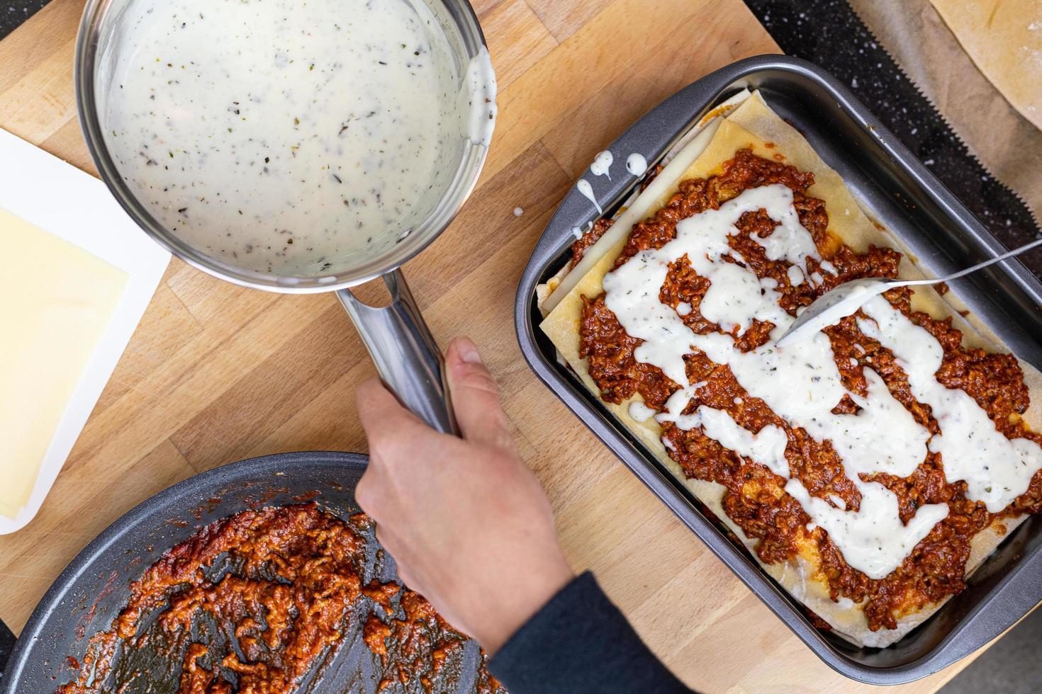 Béchamelsoße. Zubereitung der italienischen Lasagne. traditionelles italienisches Gericht. Sicht von oben. foto