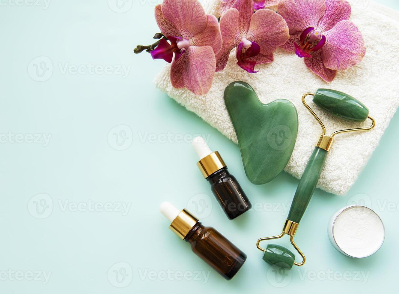 Gesichtsmassage-Jadewalze auf pastellgrünem Hintergrund foto