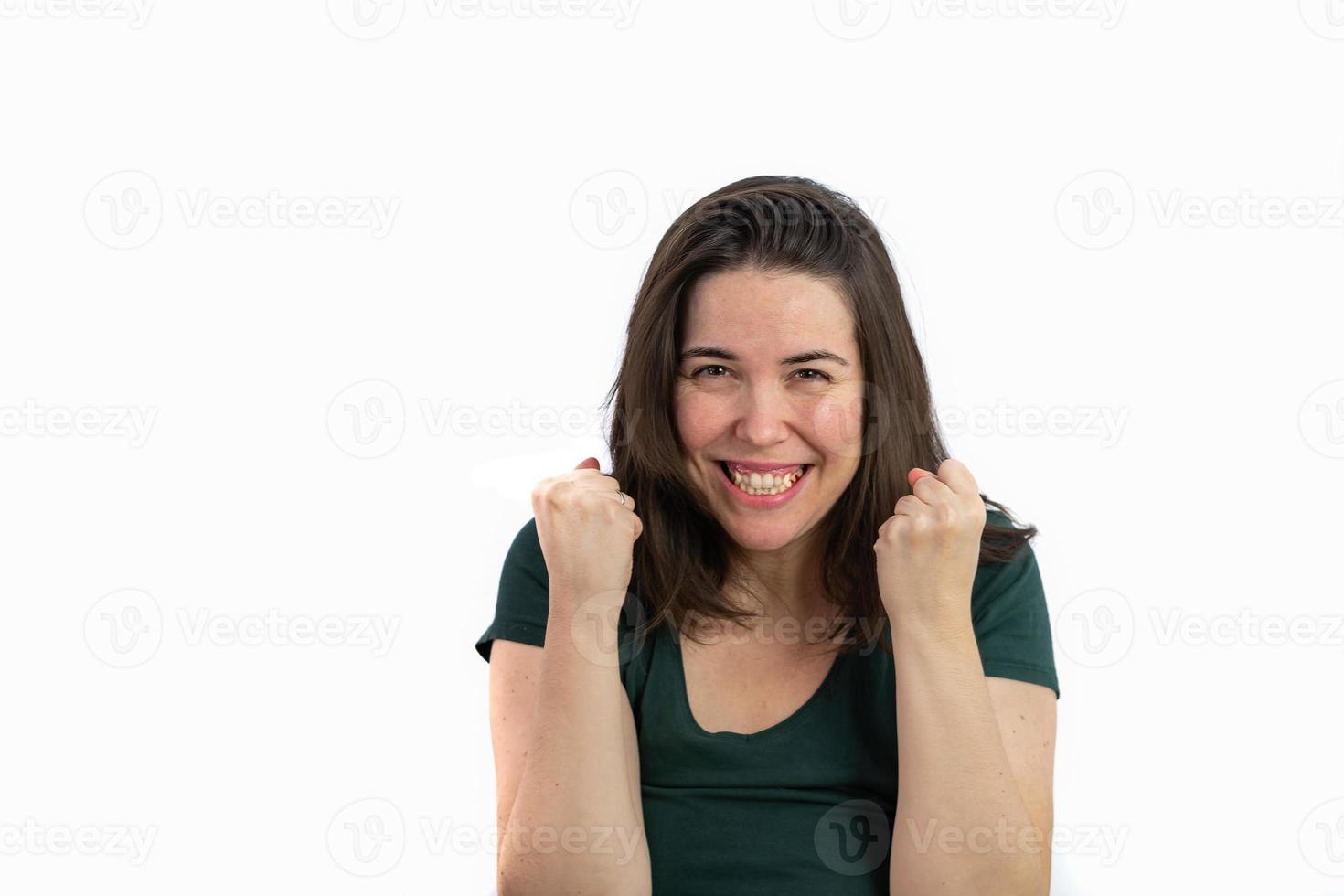 junges langhaariges brünettes Mädchen mit den Fäusten in der Luft Ausdruck des Sieges foto
