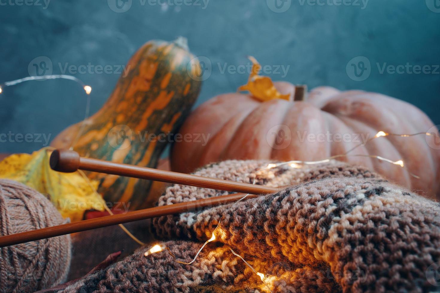 Herbstdekoration mit Garn, Holznadeln, Lichtern und bunten Kürbissen. foto