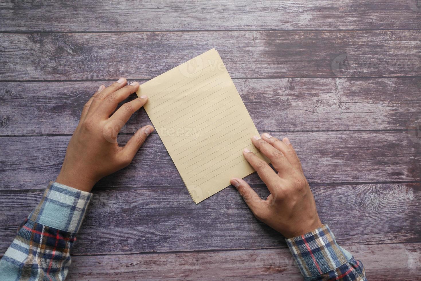 Draufsicht der Herrenhand auf leerem Papier auf dem Tisch foto