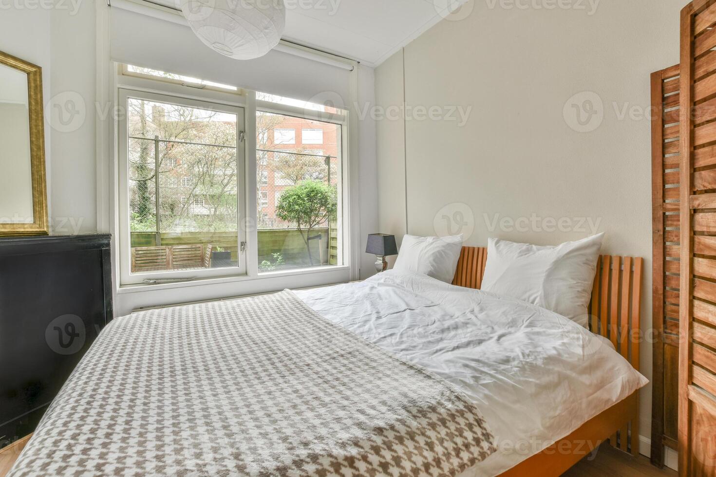 ein Schlafzimmer mit ein Bett, ein Spiegel und ein Fenster foto