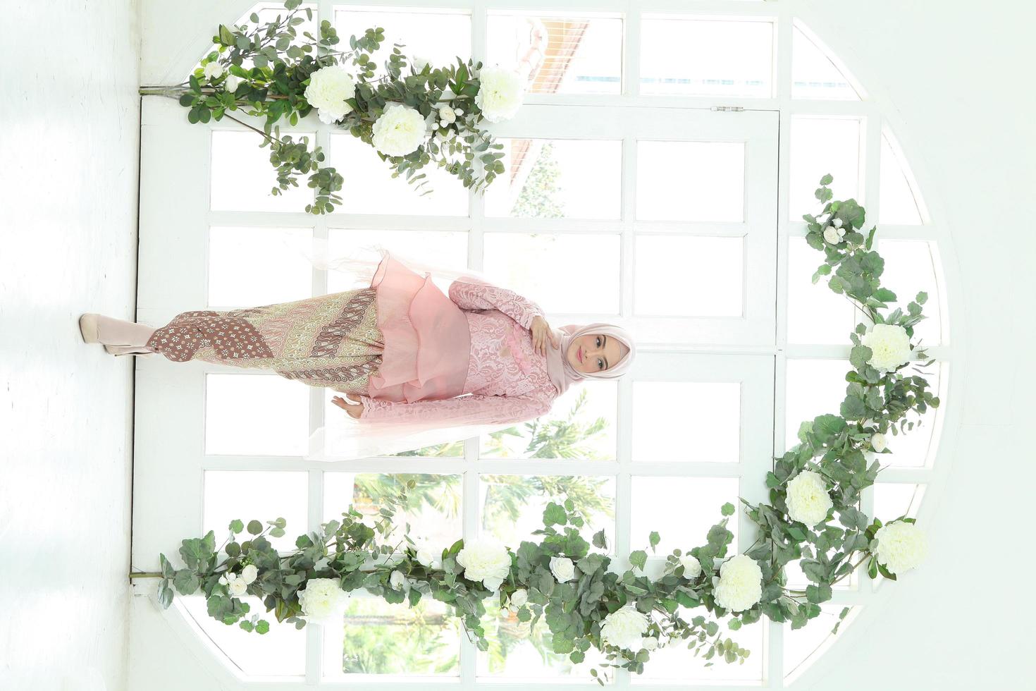 Schönes islamisches weibliches Modell mit Hijab-Mode, einem modernen Lifestyle-Outfit für muslimische Frauen. Konzept ein Hochzeitskleid, Schönheit oder Eidul Fitri. ein asiatisches Mädchenmodell mit Hijab bei einem Indoor-Fotoshooting foto