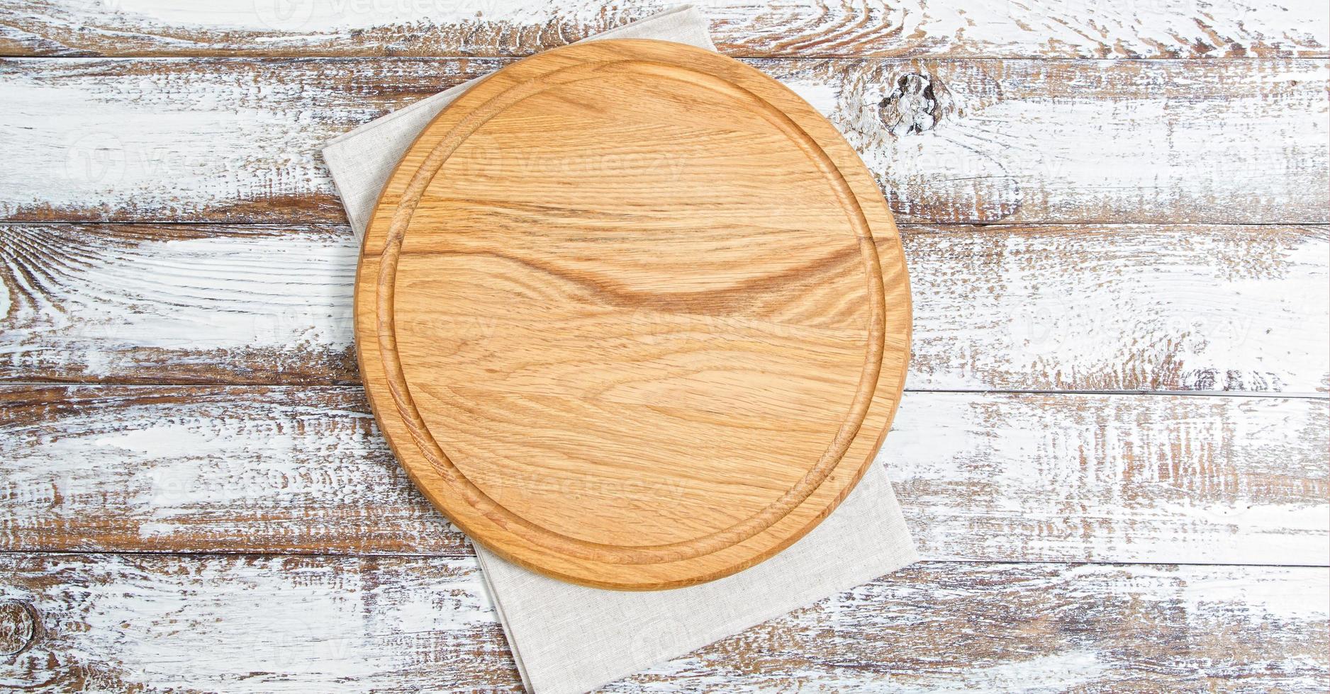 Serviette und Brett für Pizza auf Holzschreibtisch Nahaufnahme, Tischdecke. Leinwand, Geschirrtücher auf weißem Holztisch Hintergrund Draufsicht Mock-up. selektiver Fokus foto