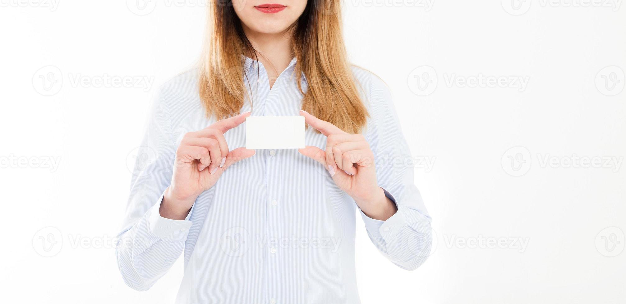 junge Frau im Hemd hält Visitenkarte auf einem weißen Hintergrund, weibliche Hand hält Karte. Unternehmenskonzept. Platz kopieren foto