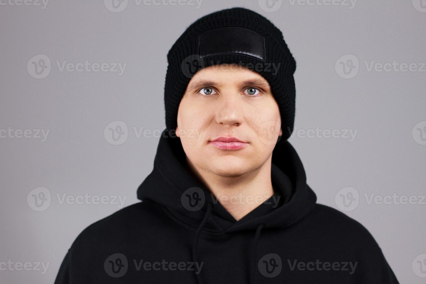 Hipster in rotem Hut und Hoodie auf grauem Hintergrund - Bild abgeschnitten foto