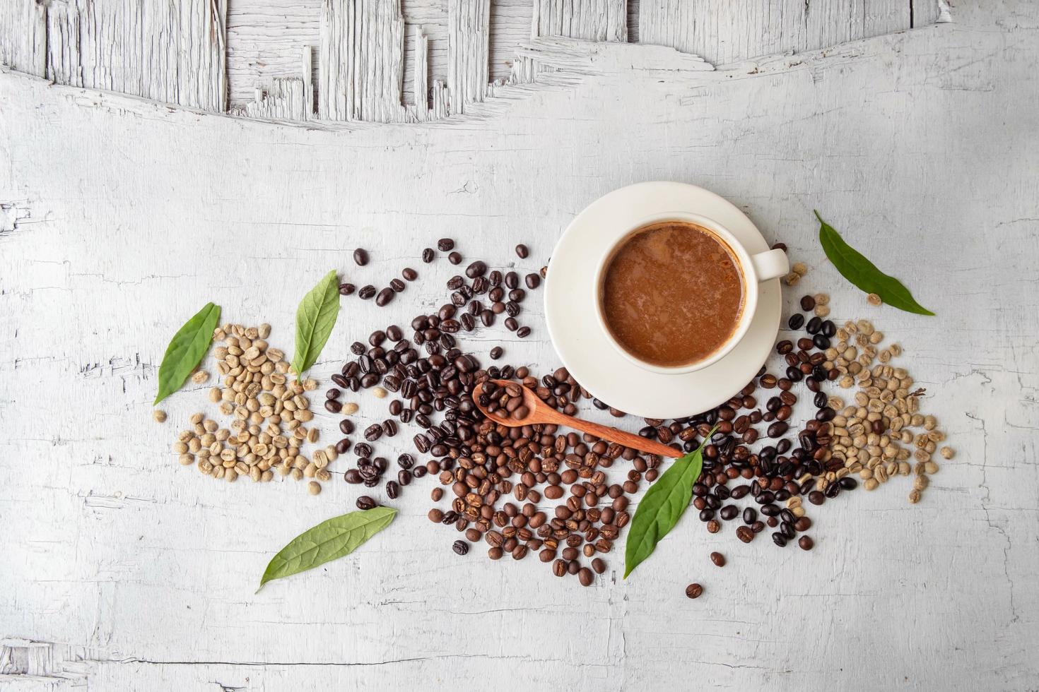 Kaffeetasse und Kaffeebohnen auf weißem Holzuntergrund foto