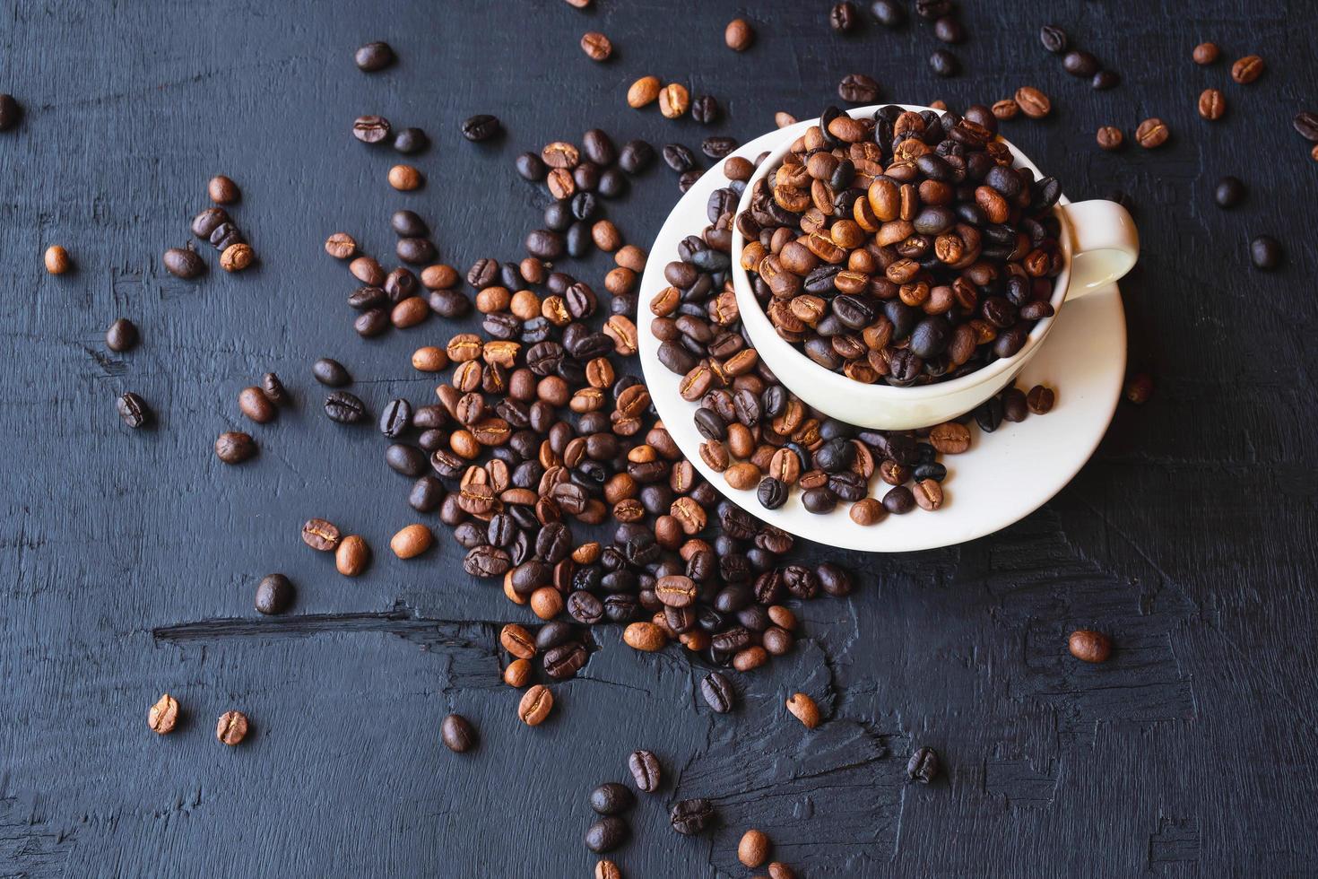 geröstete Kaffeebohnen in einer Tasse Kaffee foto