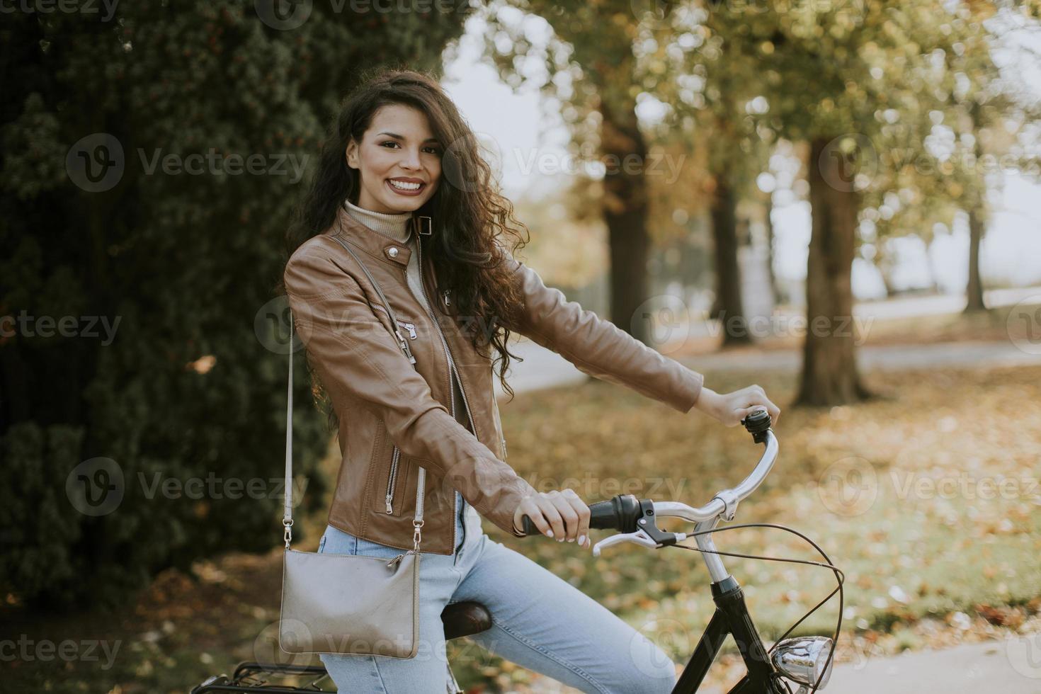 junge Frau, die am Herbsttag Fahrrad fährt foto