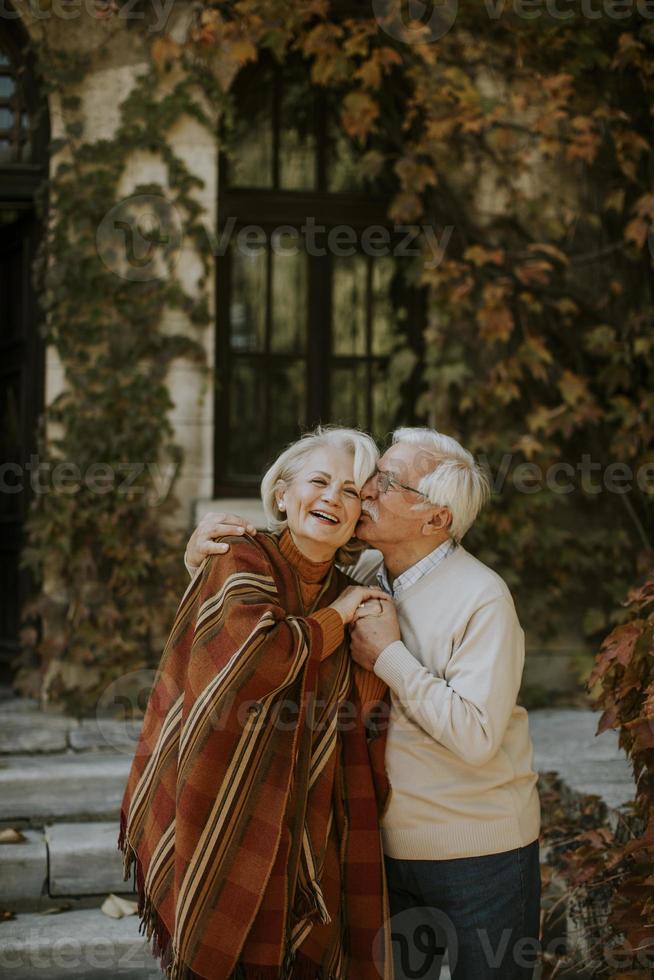 Seniorenpaar umarmt sich im Herbstpark foto