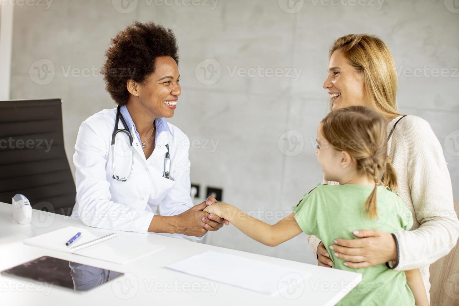 süßes kleines Mädchen mit ihrer Mutter bei der Kinderarztuntersuchung foto