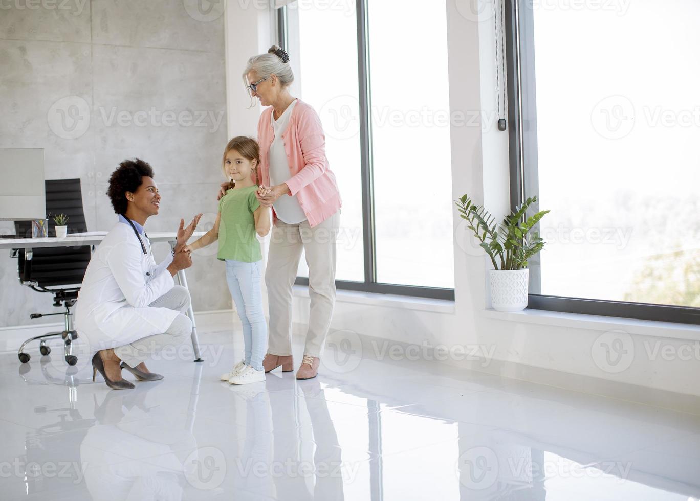 süßes kleines Mädchen mit ihrer Oma bei der Kinderarztuntersuchung foto