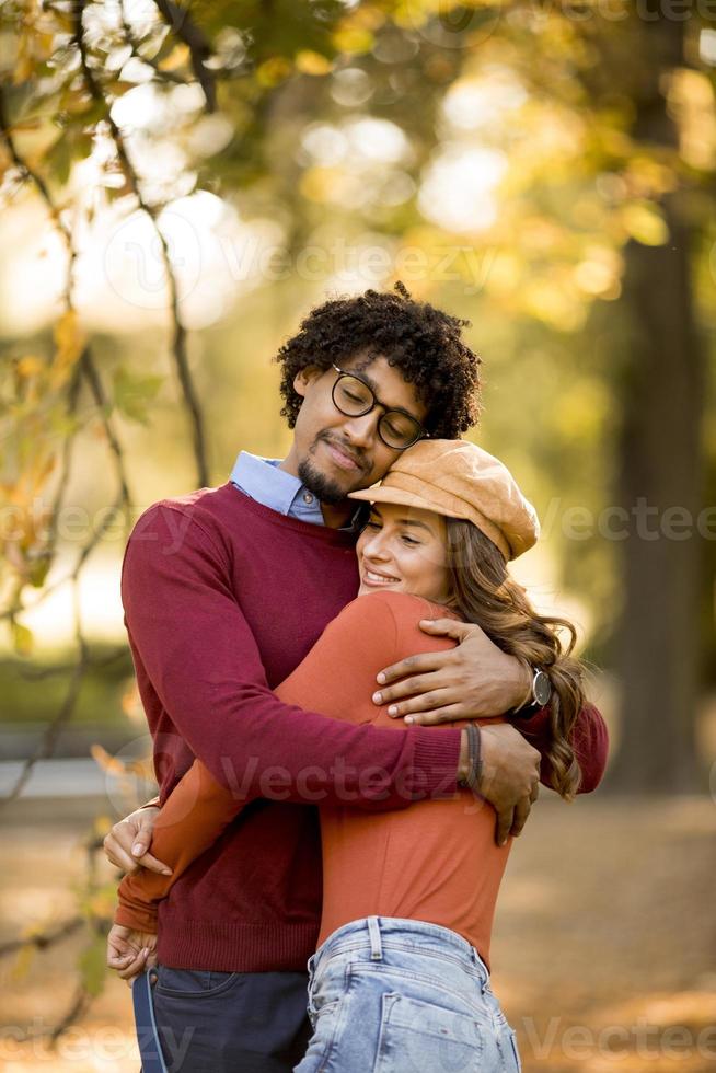 schönes Paar afroamerikanischer Mann und kaukasische Frau, die im Herbstpark spazieren gehen foto