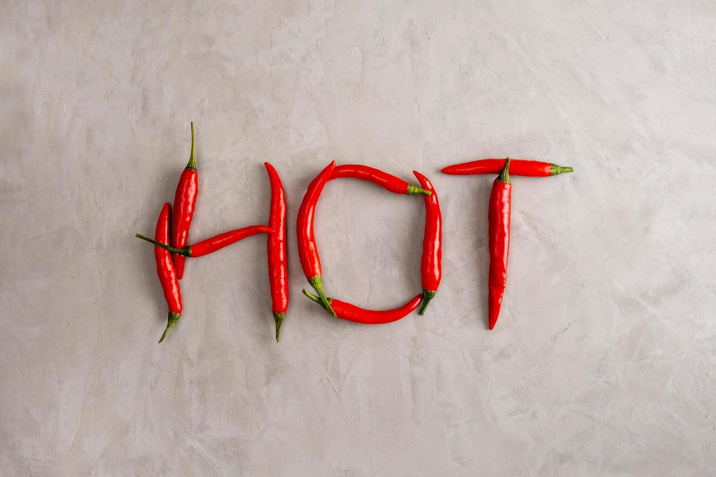 Hot-Schriftzug ist gefüttert mit Schoten roter scharfer Chilischoten foto