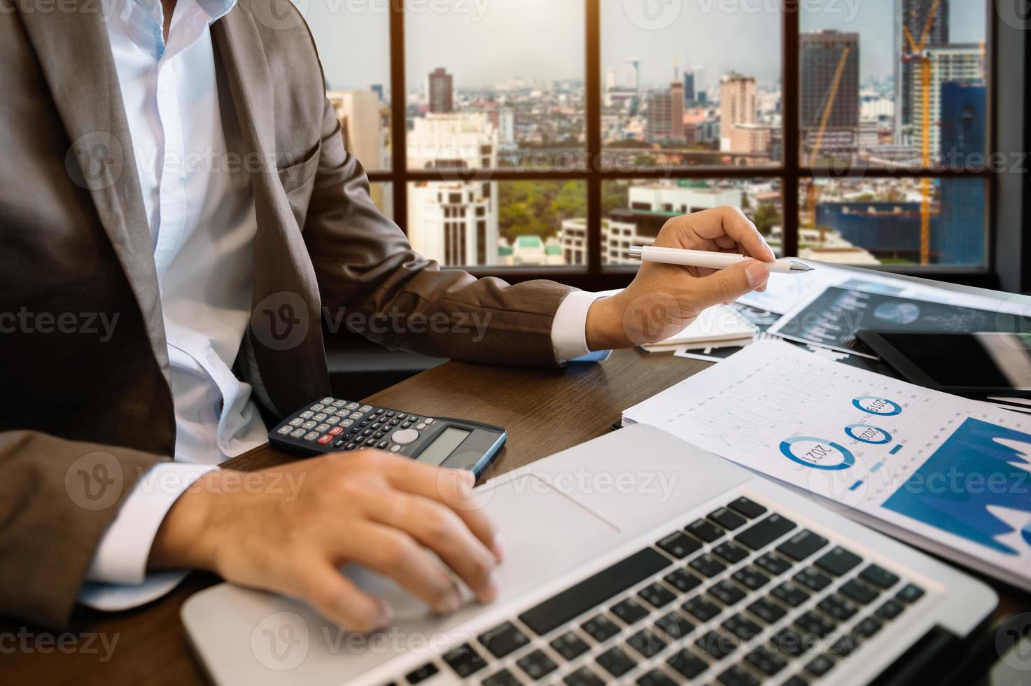 Geschäftsdokumente auf Bürotisch mit Smartphone und digitalem Tablet und Finanzdiagramm foto