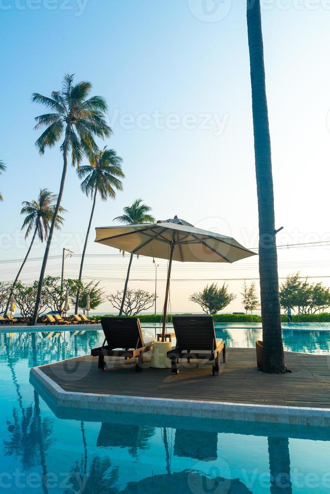 Sonnenschirm mit Bettpool um den Pool mit Ozean-Meer-Hintergrund foto