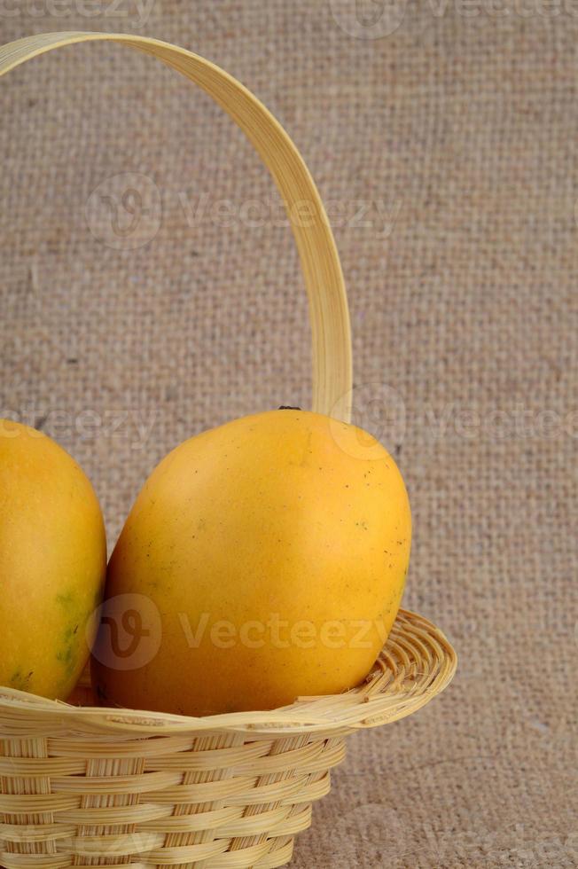 Mangofrucht im Korb auf Sackleinenhintergrund foto