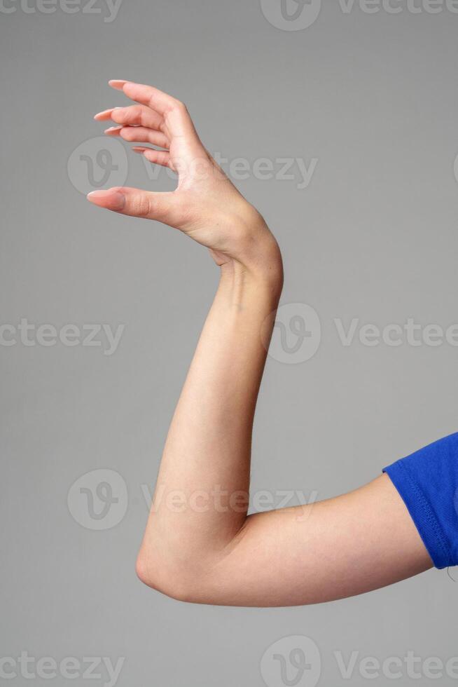 weiblich Hand Zeichen gegen grau Hintergrund im Studio foto