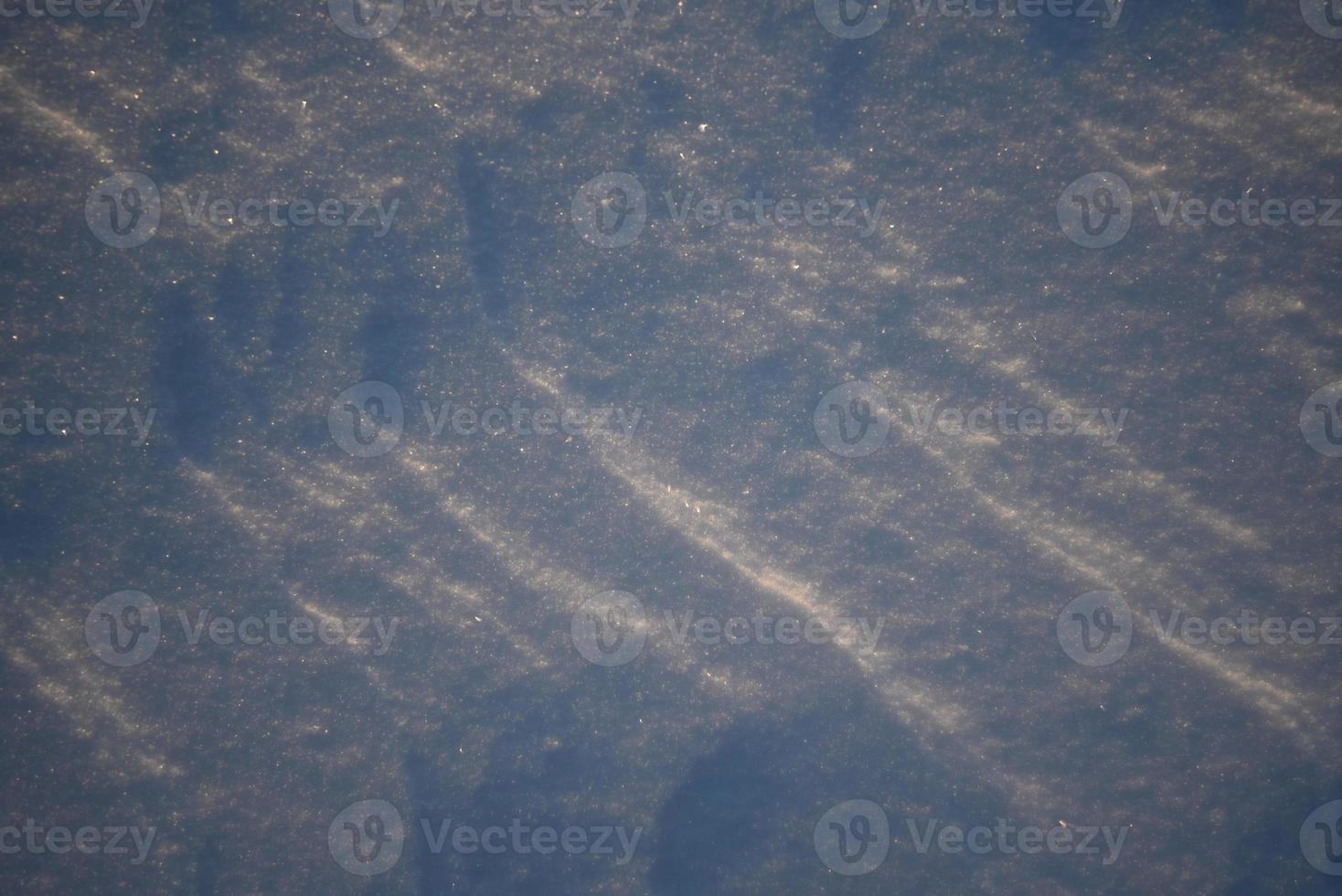 verschneite Landschaften und Schnee Nahaufnahme in Sonnenstrahlen. Gras und Gegenstände im Schnee. foto