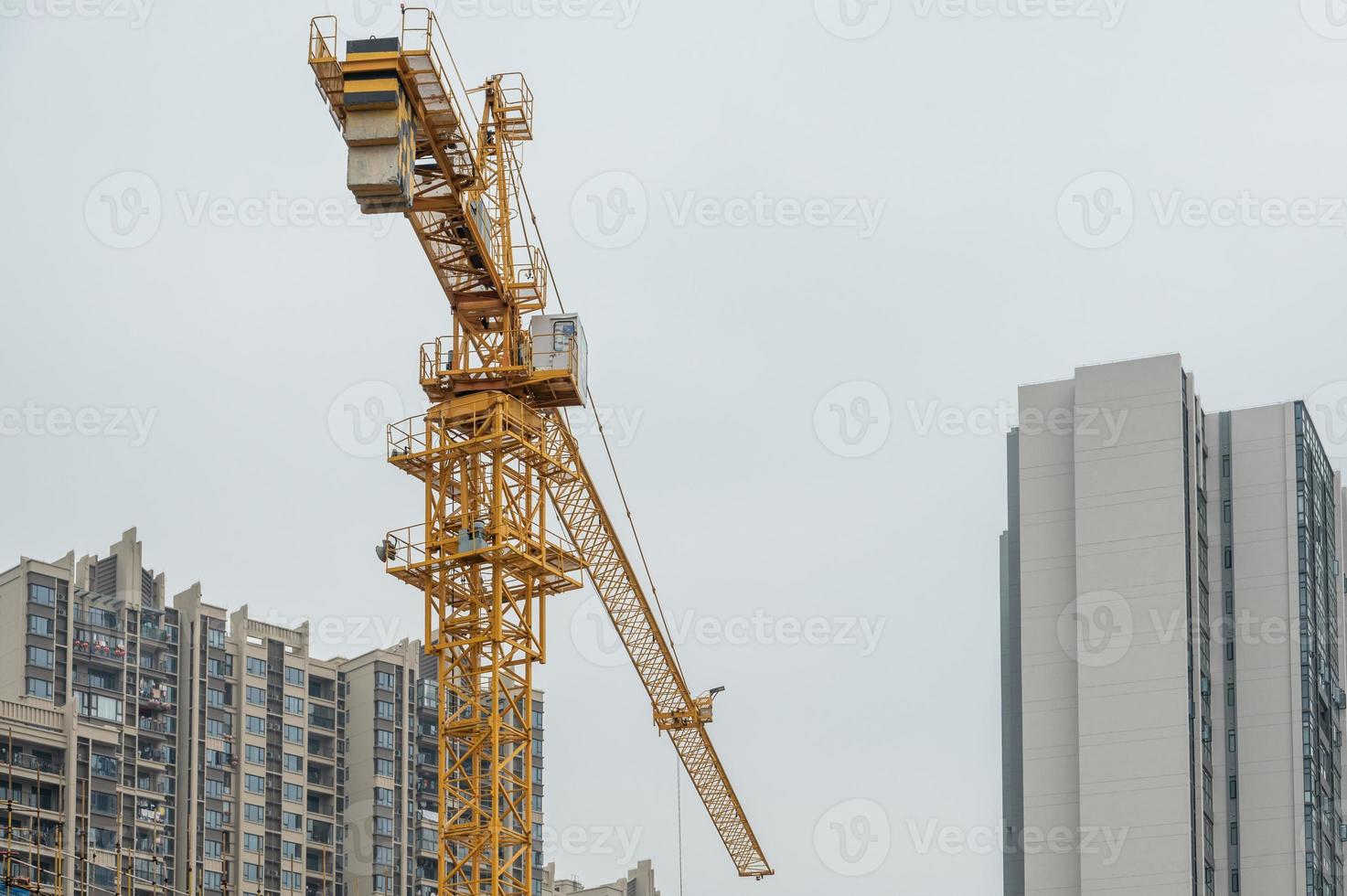 an einem bewölkten Tag arbeitet der Turmdrehkran auf der Baustelle foto