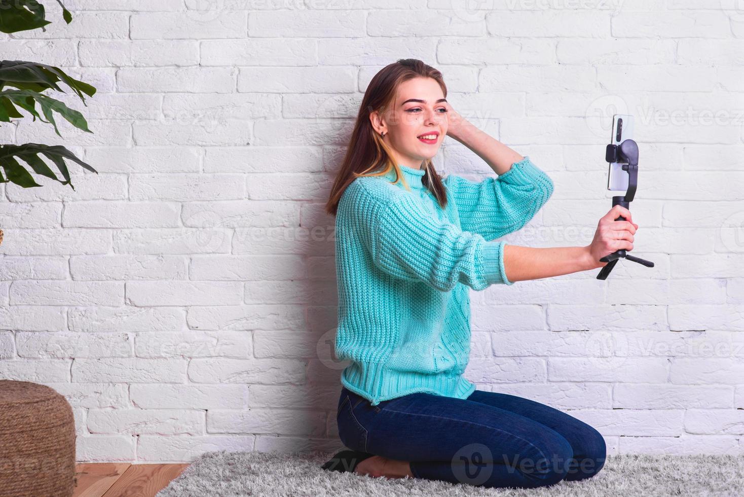 Ein hübsches Mädchen kommuniziert von zu Hause aus per Videoverbindung mit einem Smartphone. häusliche Umgebung. mit Freunden in Quarantäne kommunizieren. Home-Blogger. foto