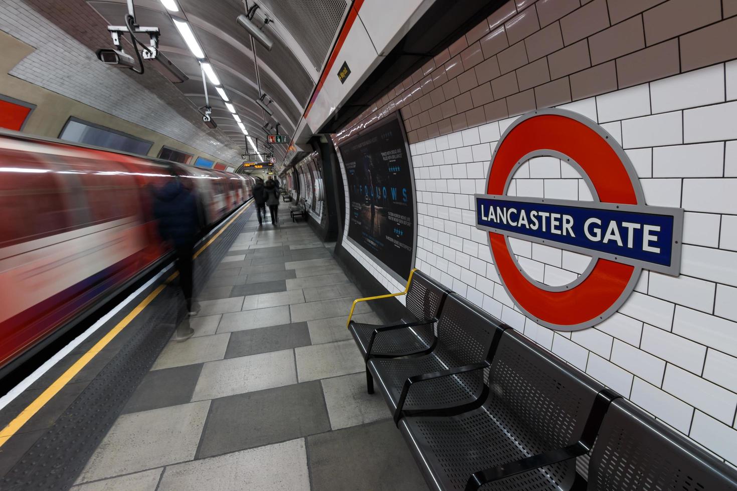 London, Großbritannien 2015, Londoner U-Bahn-Schild mit fahrendem Zug und Menschen an der Lancaster Gate Station. foto