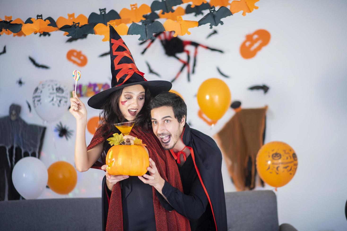 glückliches Liebespaar in Kostümen und Make-up auf einer Halloween-Feier foto