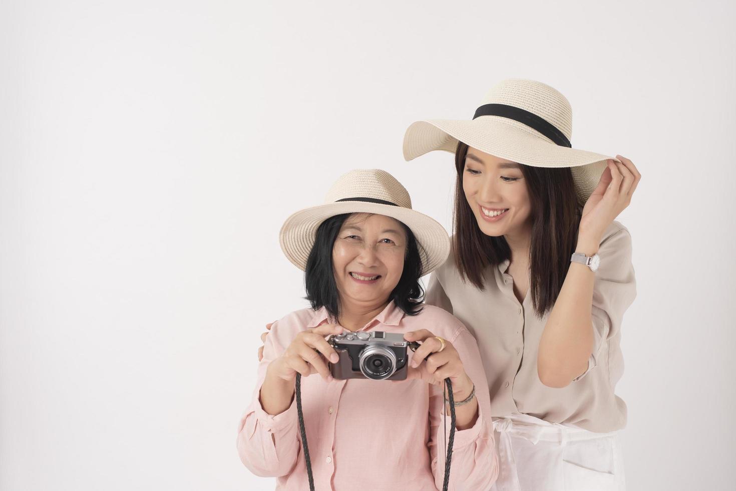 asiatische ältere Frau und ihre Tochter auf weißem Hintergrund, Reisekonzept foto