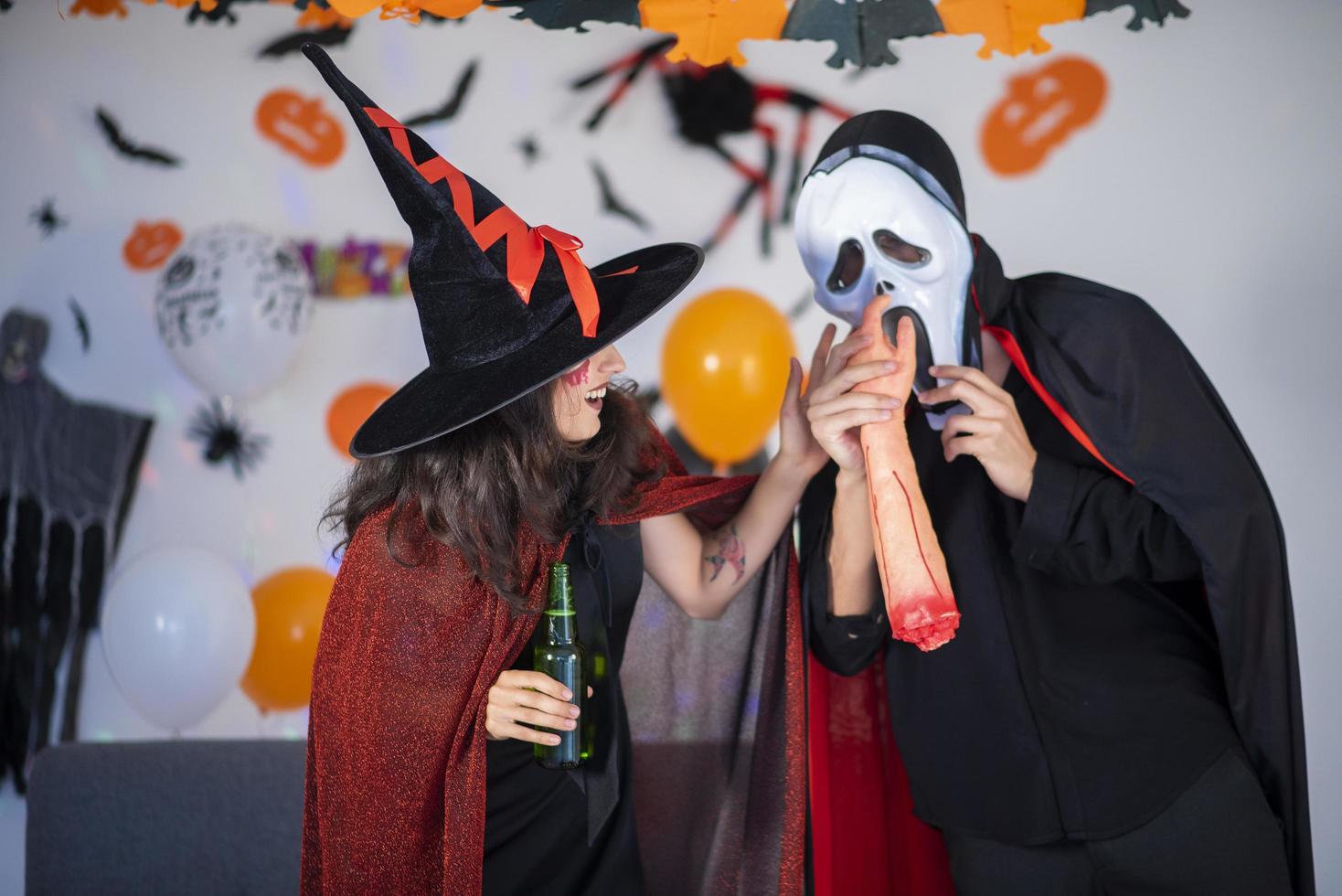 glückliches Liebespaar in Kostümen und Make-up auf einer Halloween-Feier foto