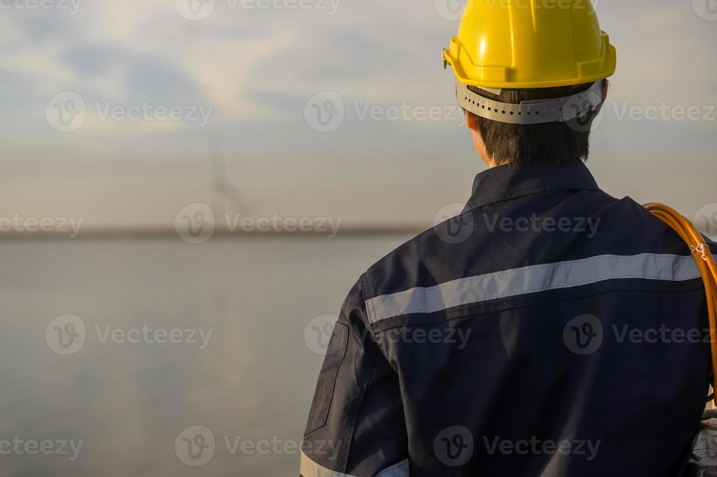 ein männlicher Ingenieur, der bei Sonnenuntergang einen Schutzhelm trägt. foto