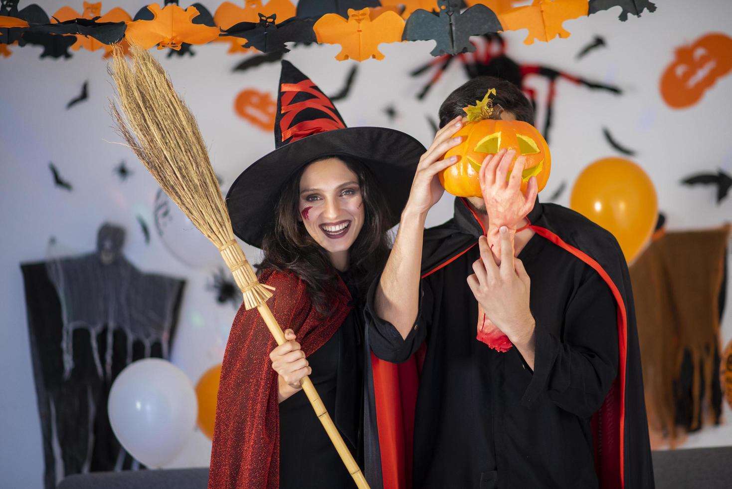 glückliches Liebespaar in Kostümen und Make-up auf einer Halloween-Feier foto