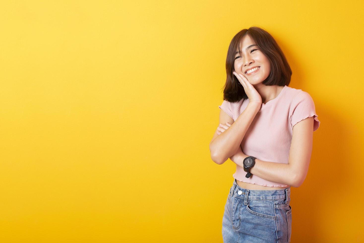 schöne asiatische Studentin glücklich auf gelbem Hintergrund foto