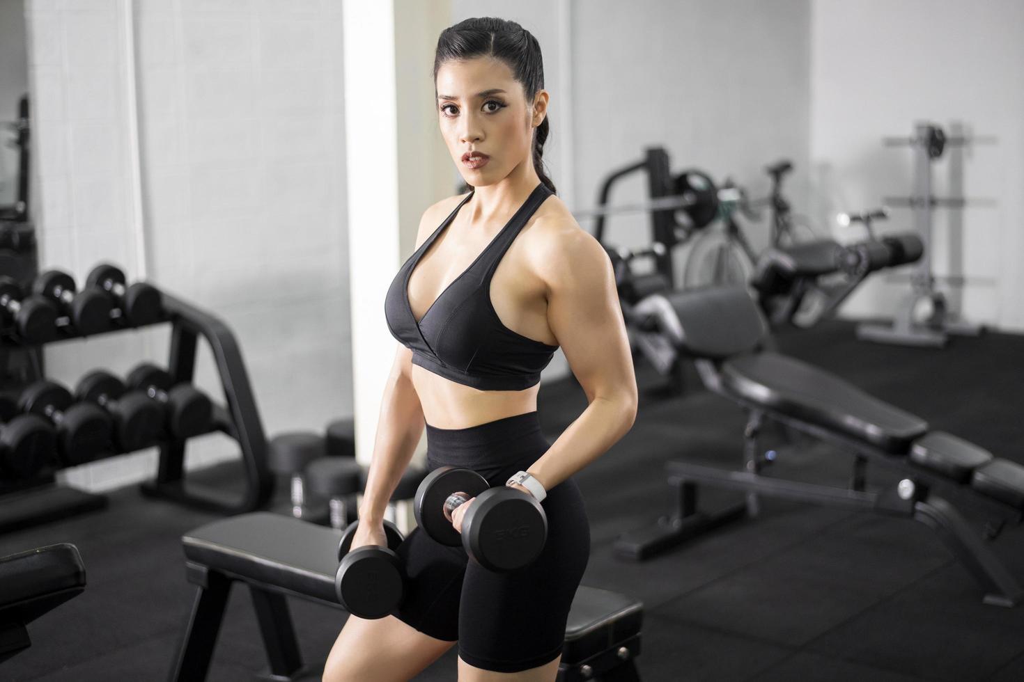 Schöne Frau mit perfektem Körper trainiert im Fitnessstudio foto