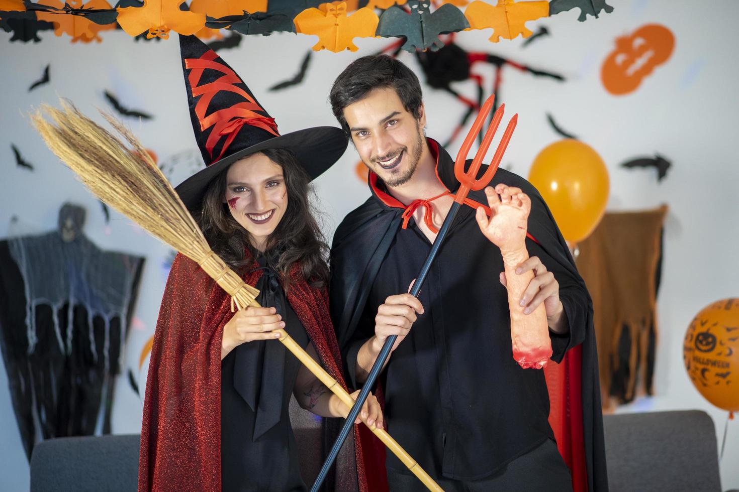 glückliches Liebespaar in Kostümen und Make-up auf einer Halloween-Feier foto