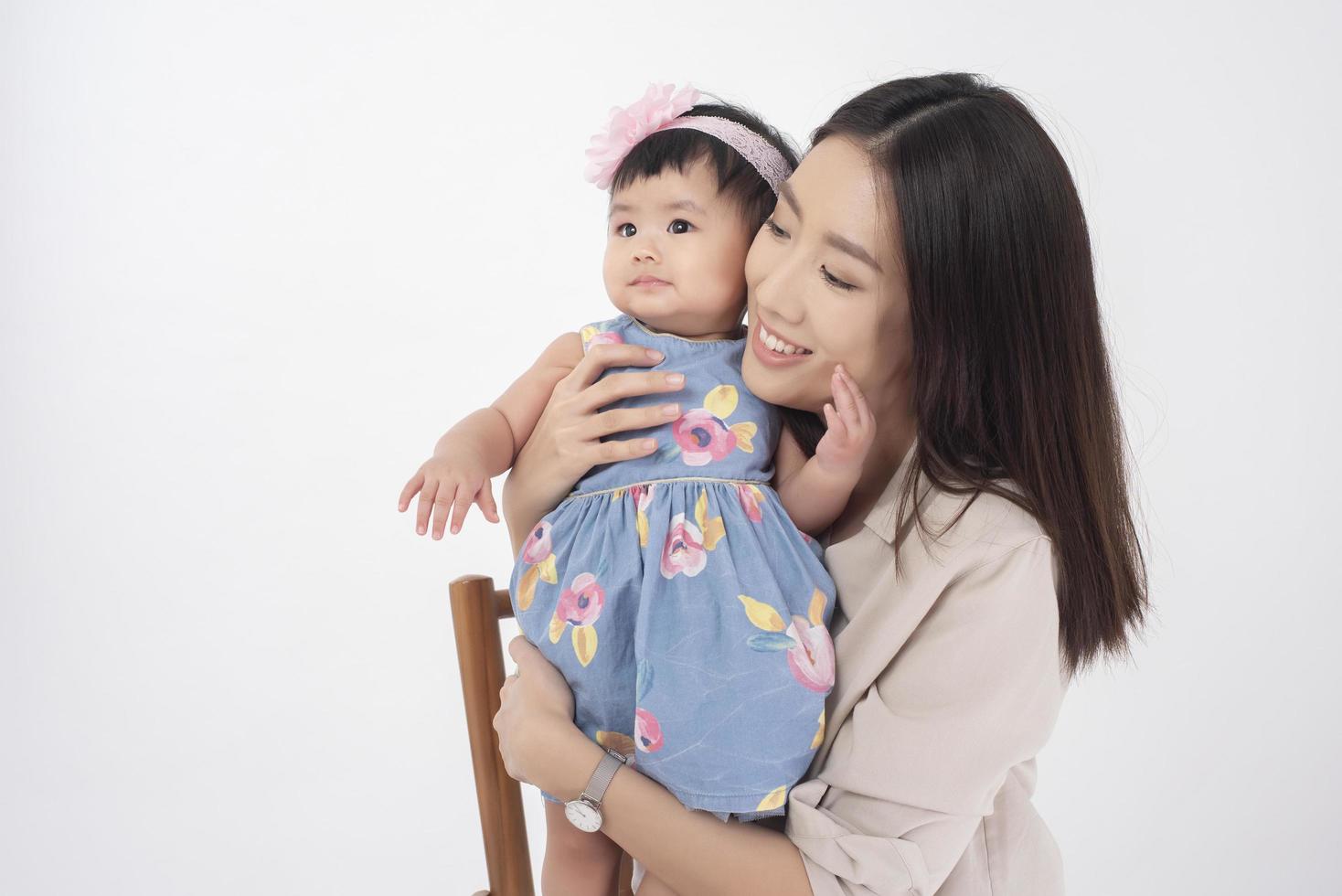 asiatische Mutter und entzückendes Baby sind glücklich auf weißem Hintergrund foto