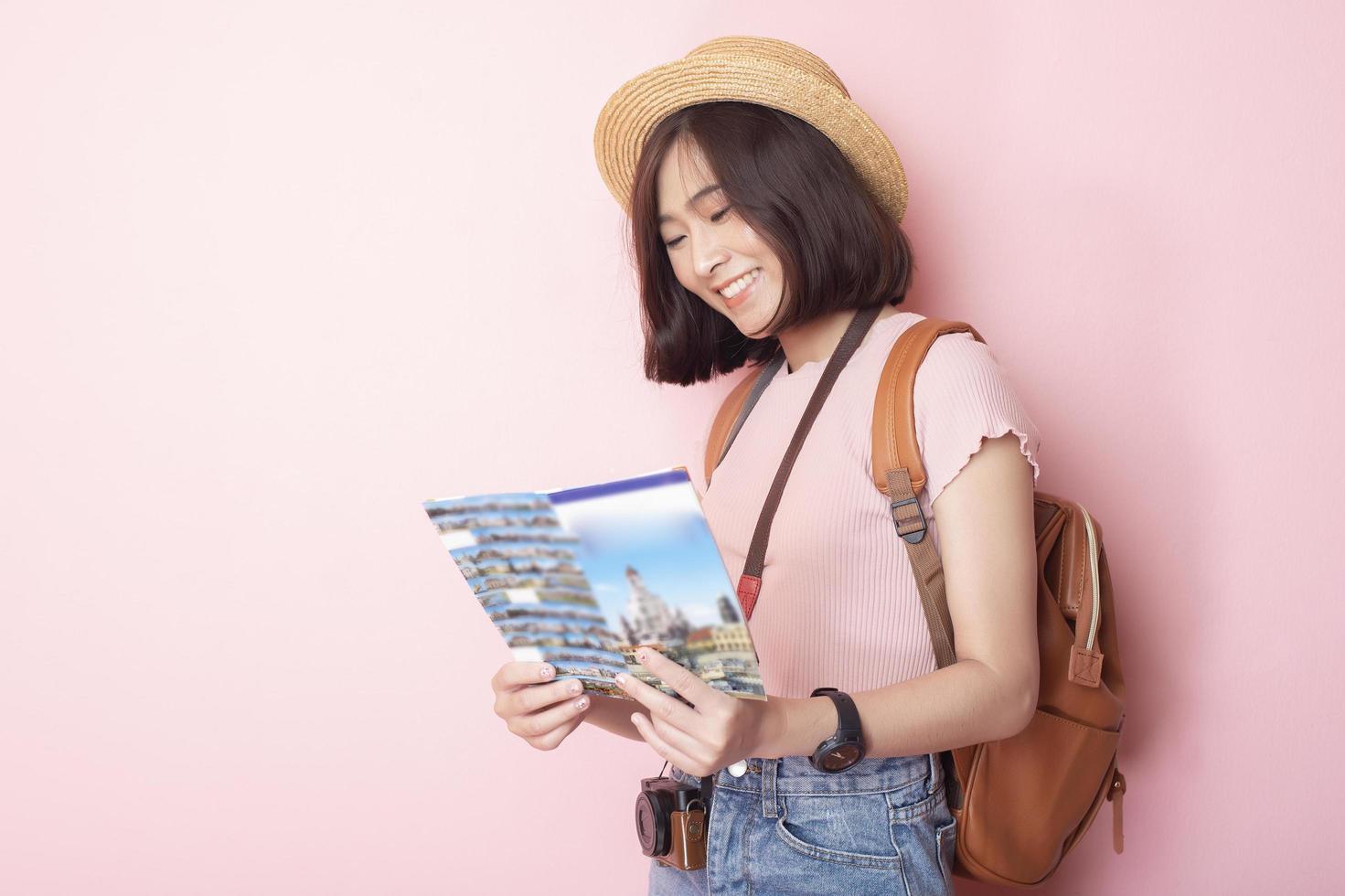 glückliche asiatische Touristin auf rosa Hintergrund foto