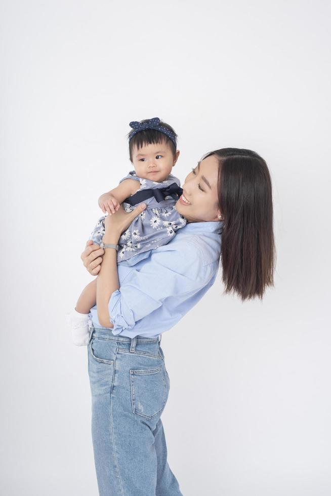 asiatische Mutter und entzückendes Baby sind glücklich auf weißem Hintergrund foto