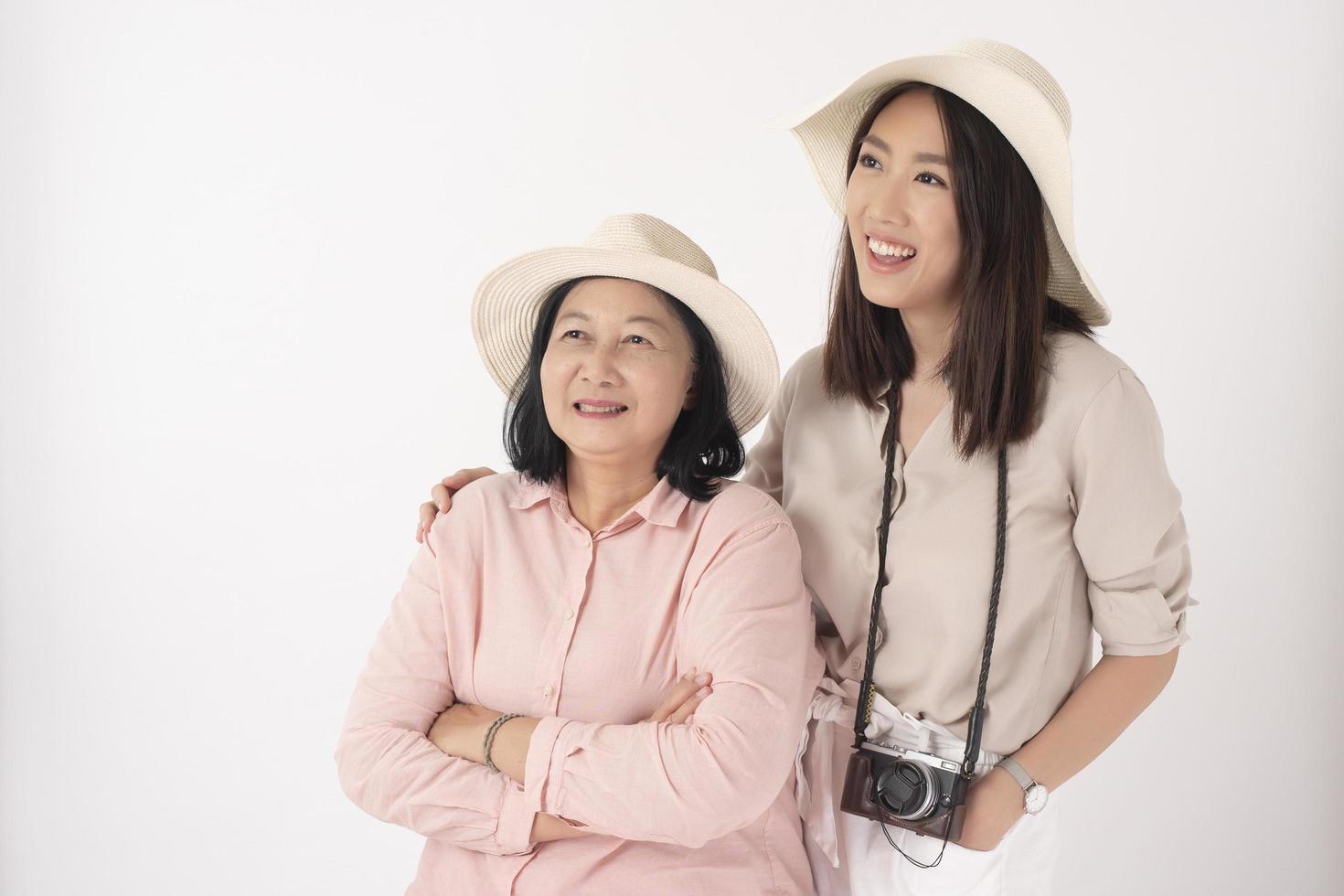 asiatische ältere Frau und ihre Tochter auf weißem Hintergrund, Reisekonzept foto