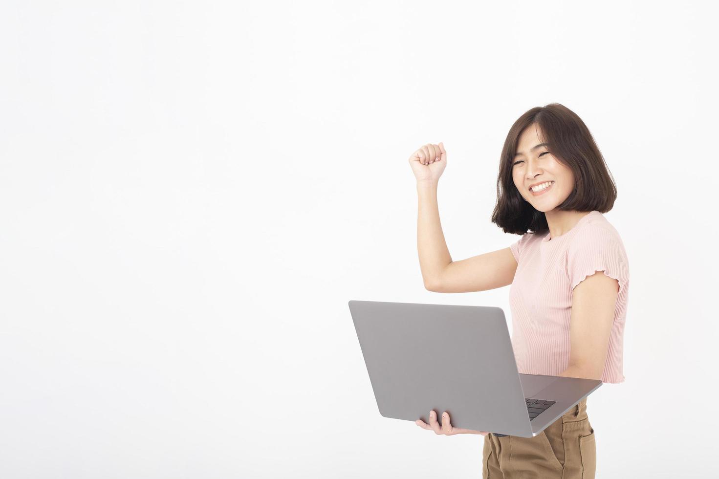 Süße asiatische Teenager-Frau arbeitet mit Computer auf weißem Hintergrund foto