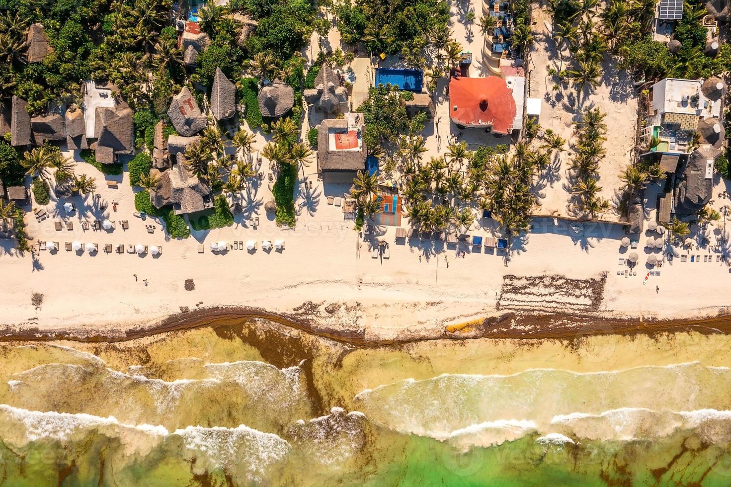 luftige küste von tulum am strand mit einem magischen karibischen meer und kleinen hütten an der küste. foto