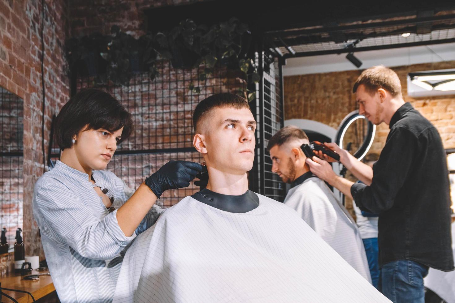 Friseure schneiden ihre Kunden im Friseursalon. Werbe- und Friseurkonzept foto